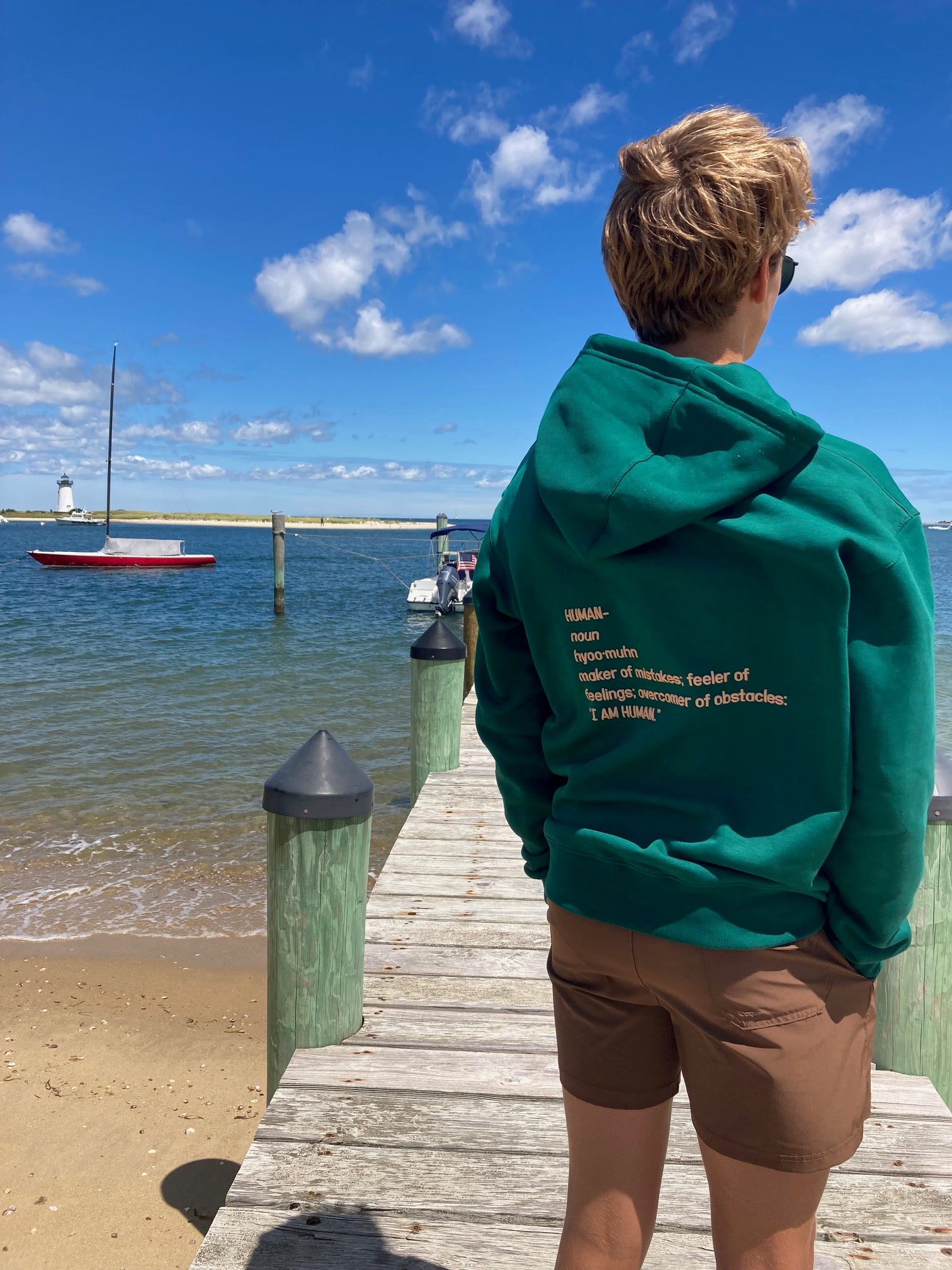 Back view of Robbie wearing green human definition hoodie in a size Medium. 