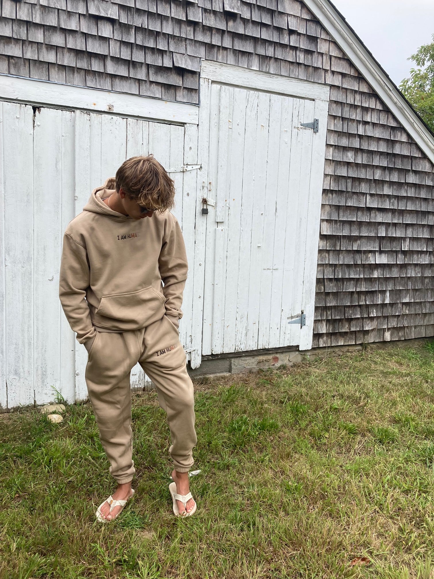 Picture of Robbie in medium tan logo hoodie and jogger set. 