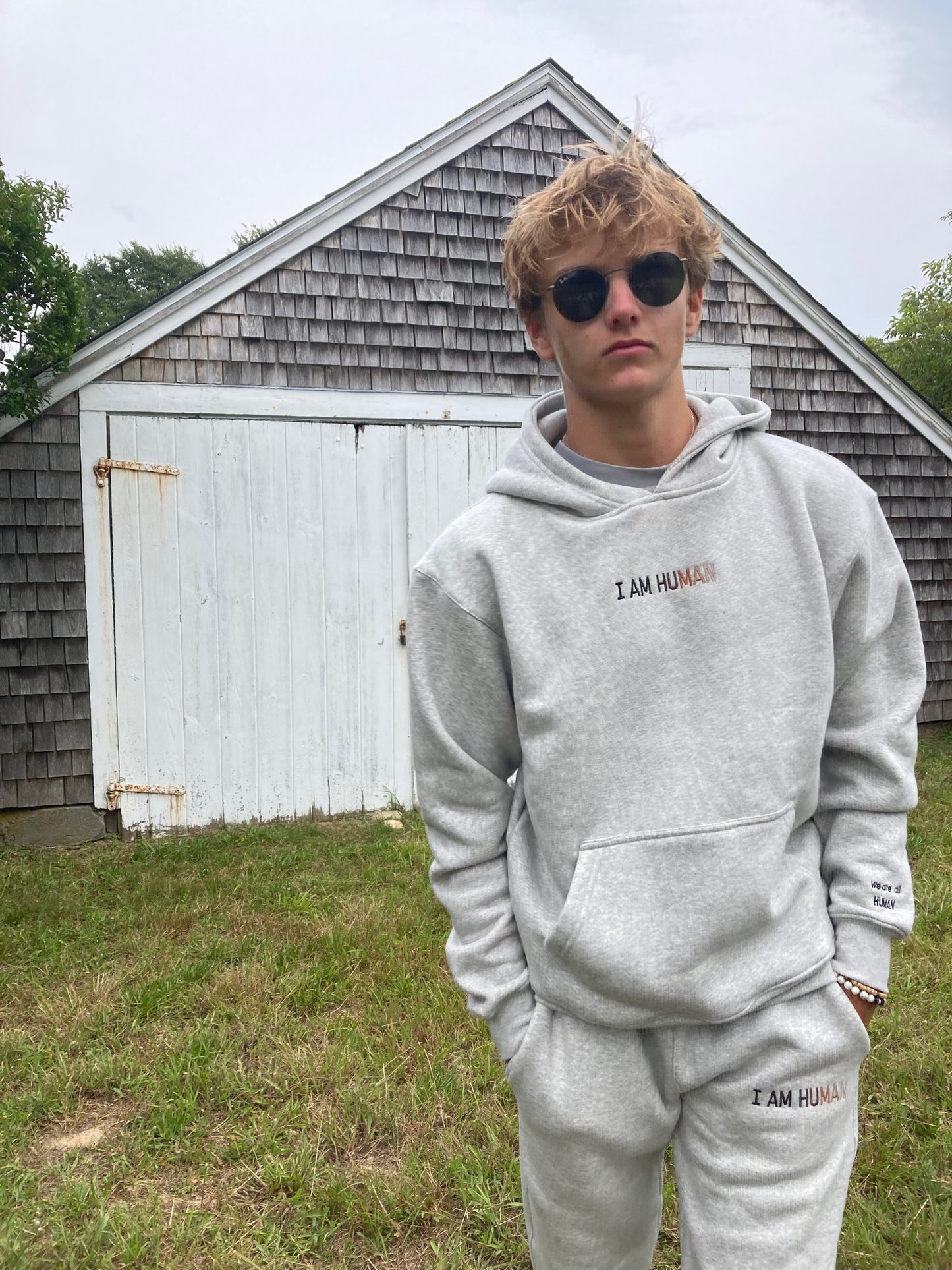 Front view of Robbie in grey I AM HUMAN logo hoodie size Medium.