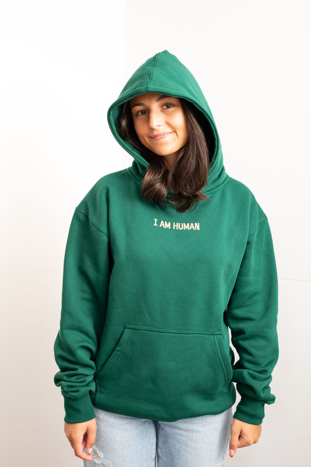 Front view of Elizabeth in green hoodie with I AM HUMAN written on the chest in tan lettering. 